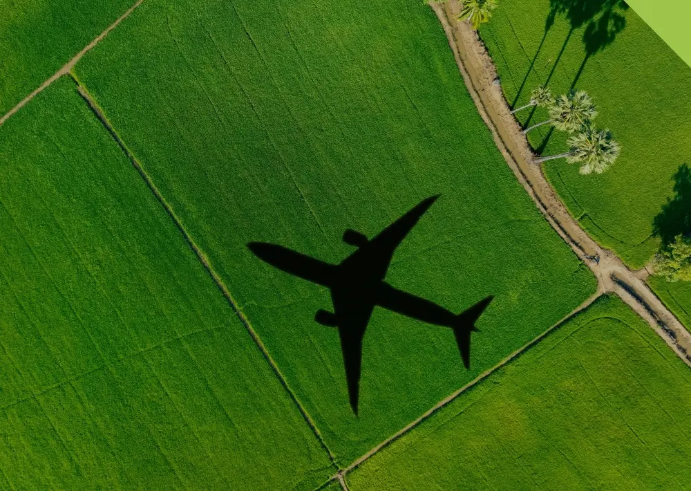 An aircraft's shadow over farmland — CORSIA links international aviation emissions to high-integrity carbon credits.